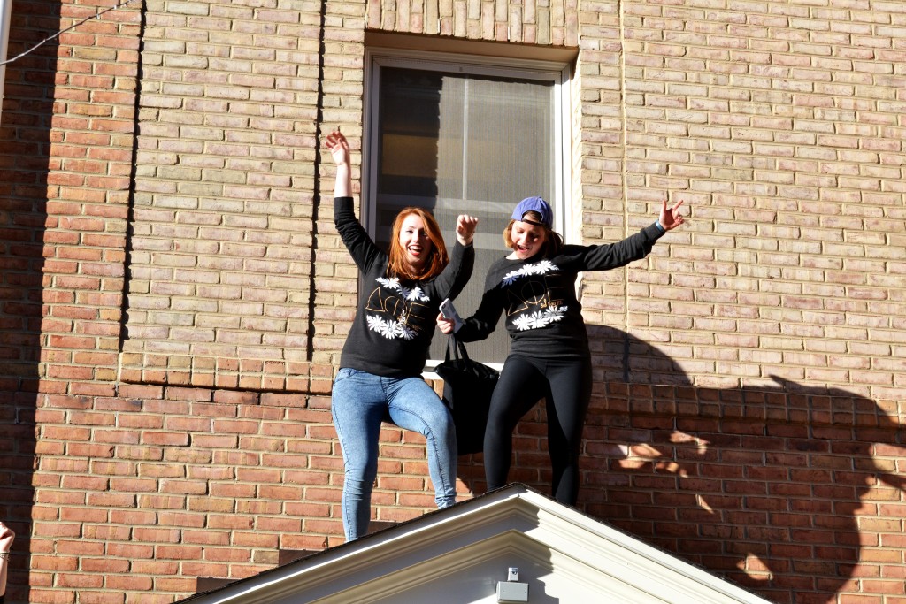 Two women dance on top of one of the sorority lodges after accepting bids to join a sorority| Photo by Erin Baker, Staff