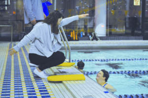 College junior Shelby Fruge demonstrates a swimming technique to a swimmer of the local Metro Ducks team. Emory's swimming and diving team helps out the local Special Olympics team for an hour every Tuesday | Gemy Sethaputra/Senior Staff