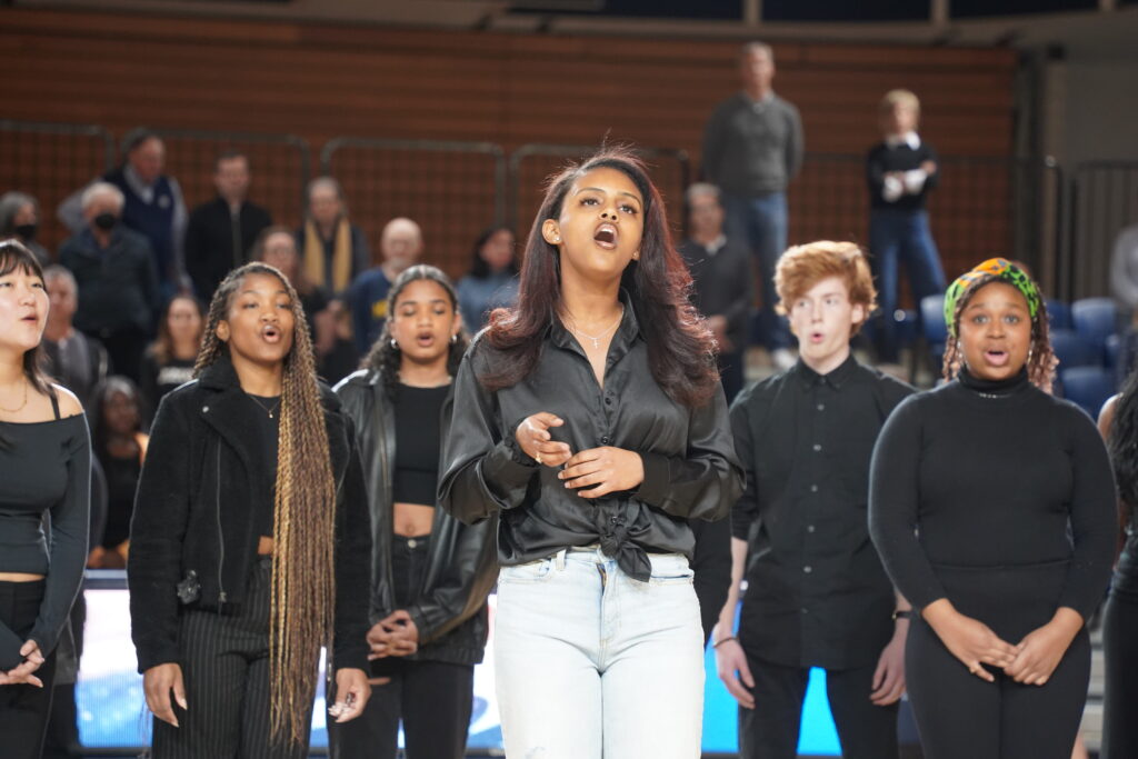 Members of AHANA A Capella sing "Lift Every Voice and Sing" at the blackout game on Feb. 9. (Justin Whitening/Contributing Photographer)